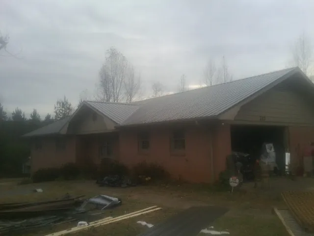 Gray metal roof on a stucco house with an attached garage in Saltillo