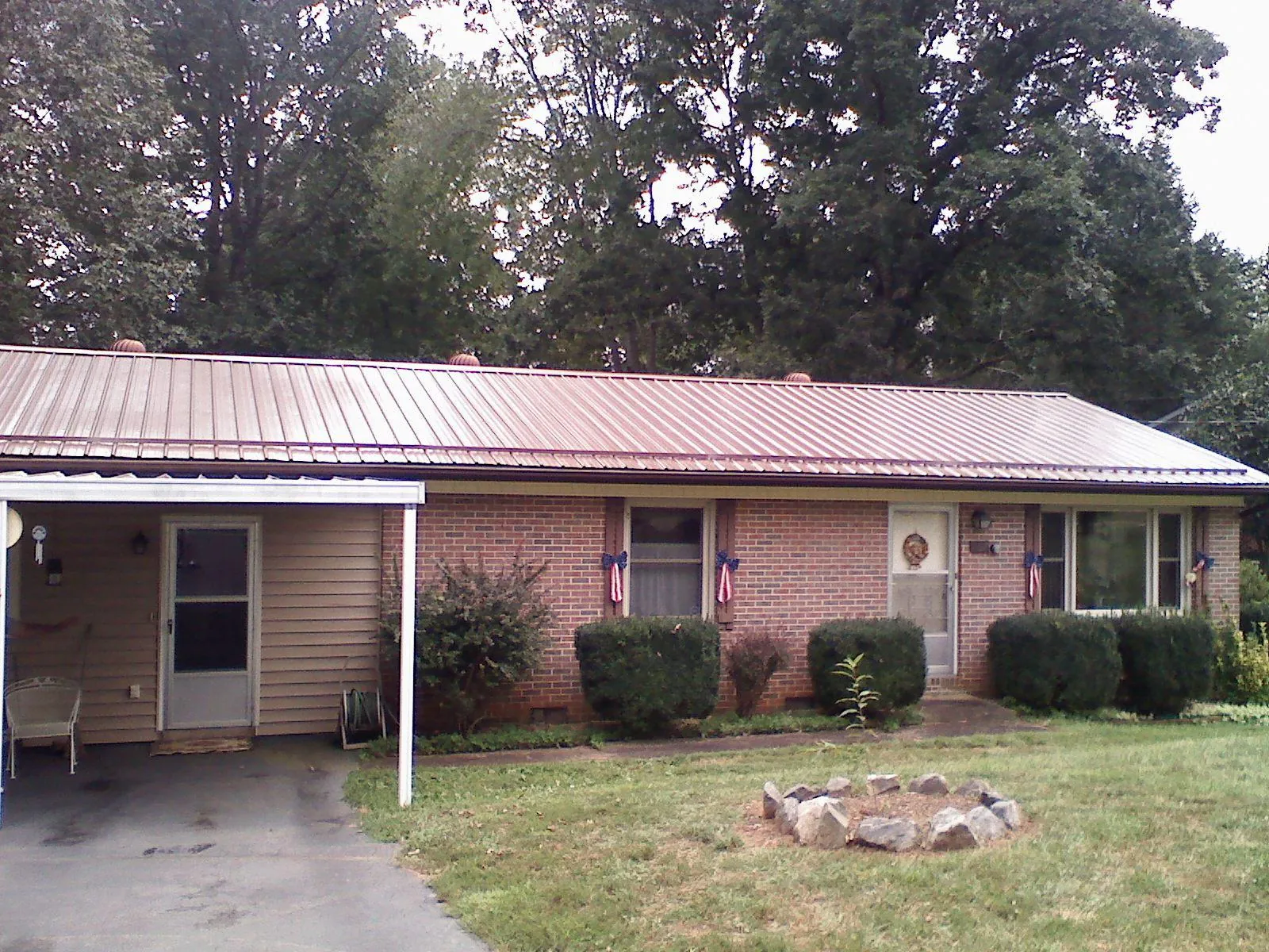 Bronze metal roof and carport on a brick ranch home — Roof Repair work by our crew in Saltillo